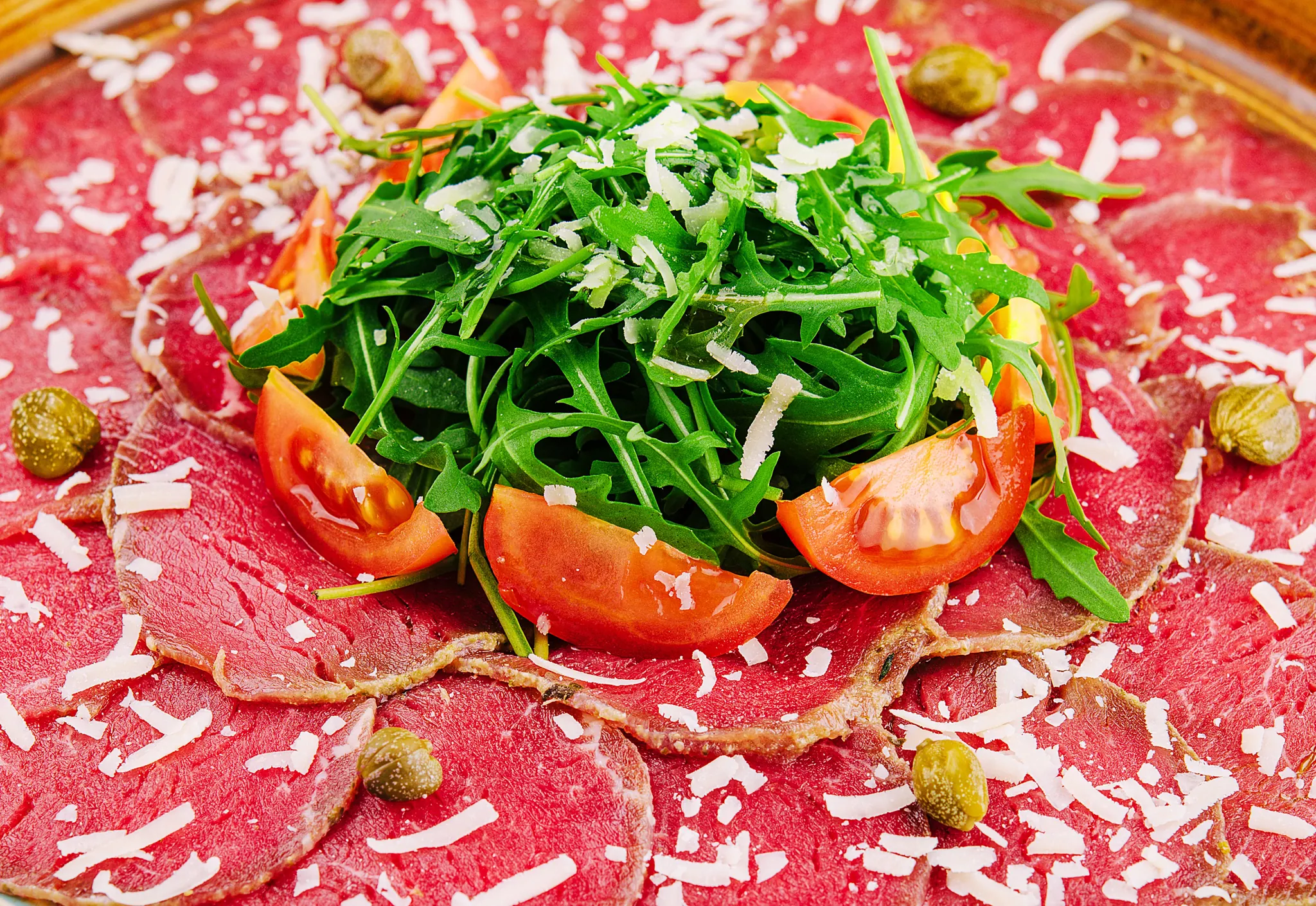 Beef carpaccio with rocket, tomatoes and capers