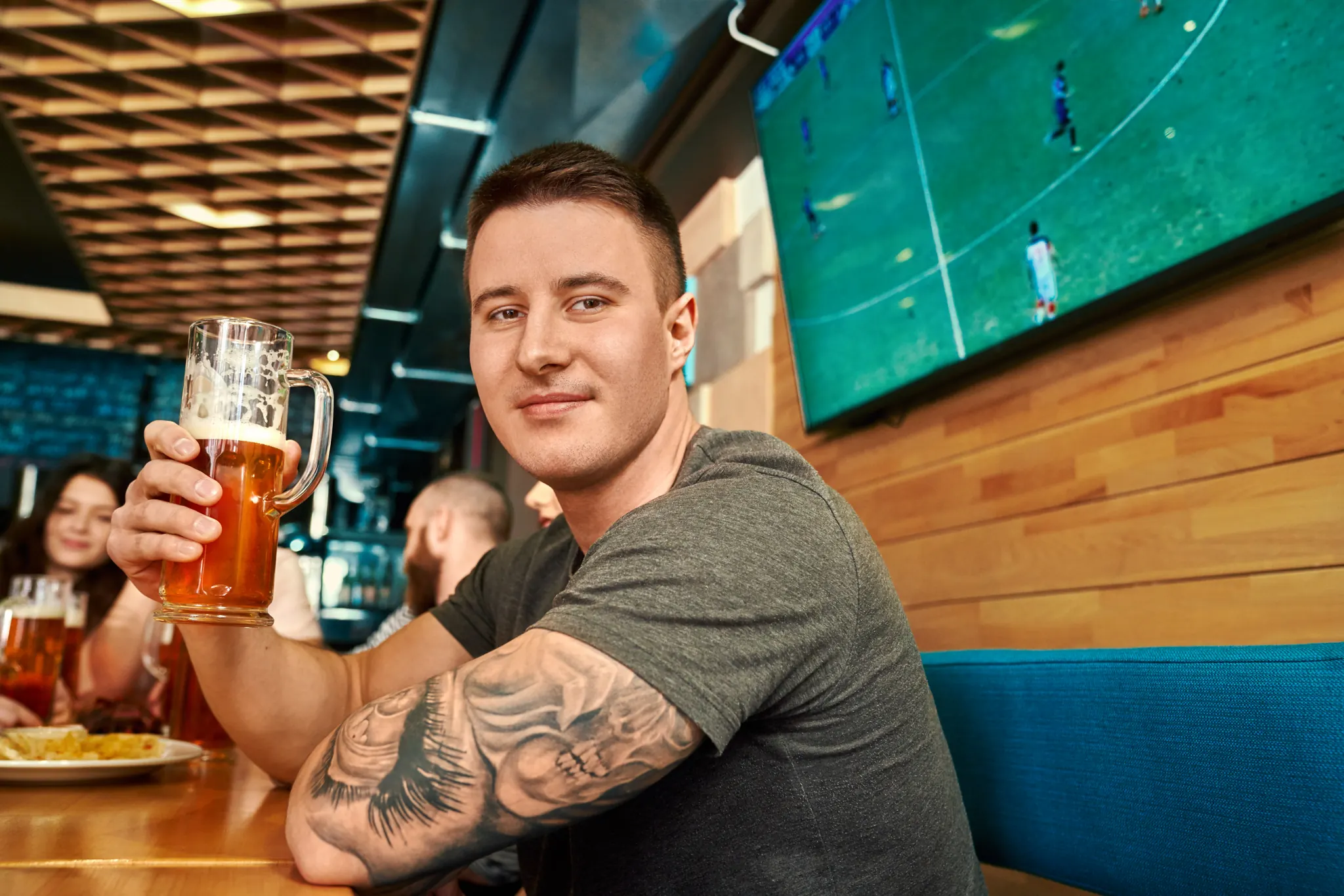 Man enjoying a beer while watching the game at the bar