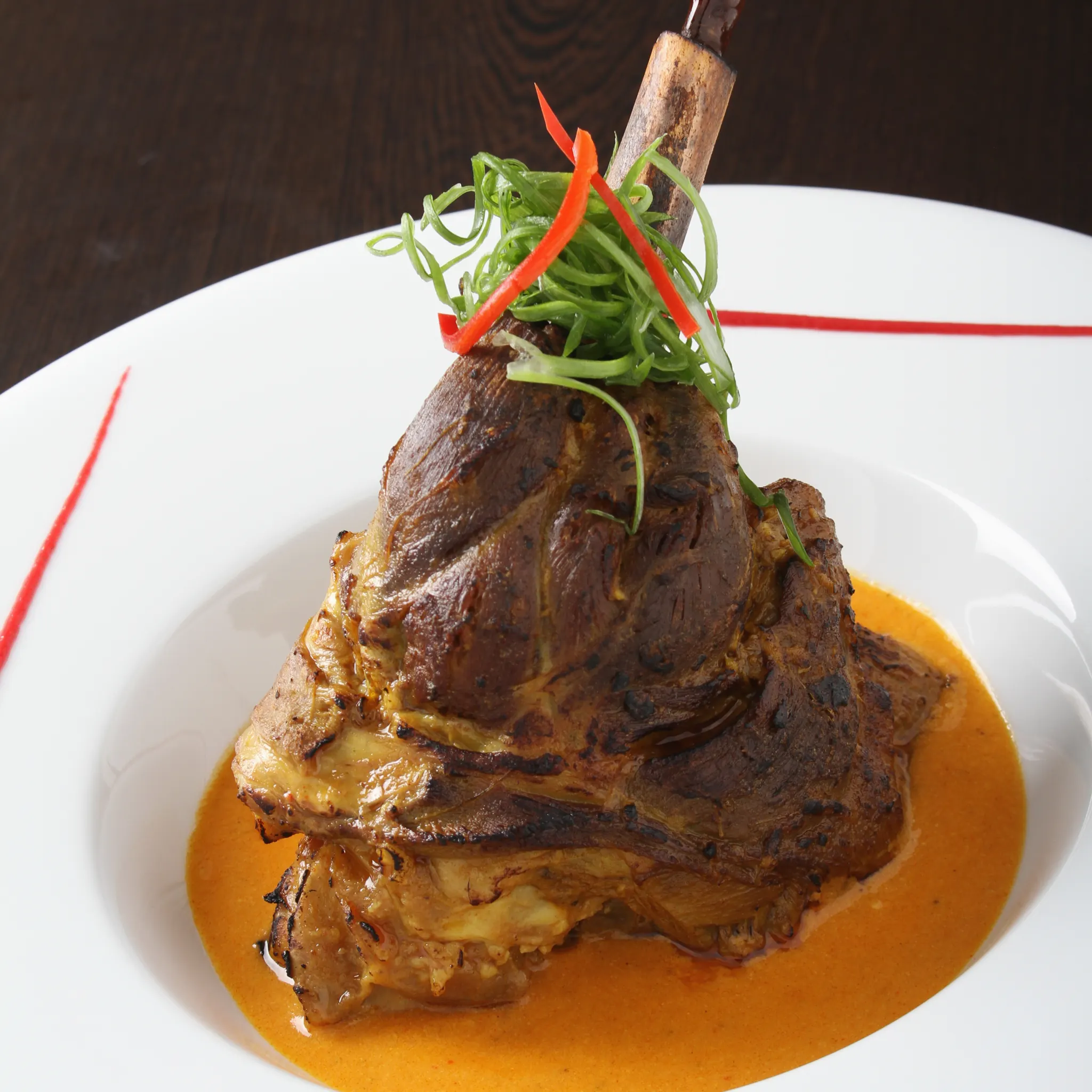 Slow-cooked lamb shank with colourful garnish